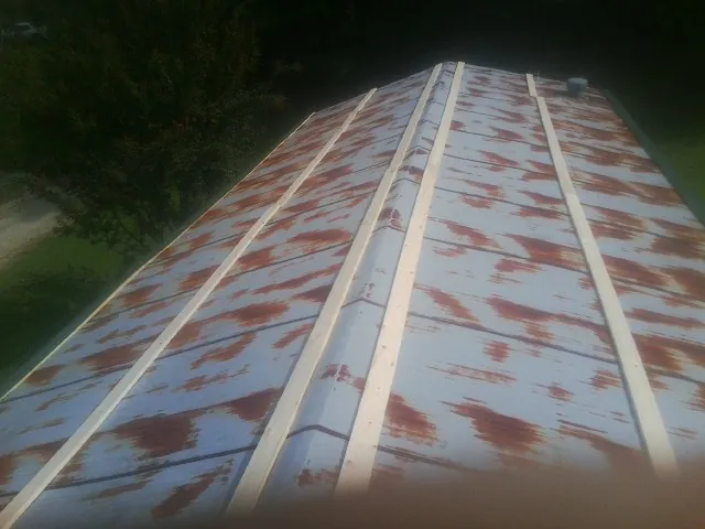 Rusted metal roof panels with new wood purlins before replacement — Storm Damage Roof Repair in Portage Des Sioux by Roofing Brothers