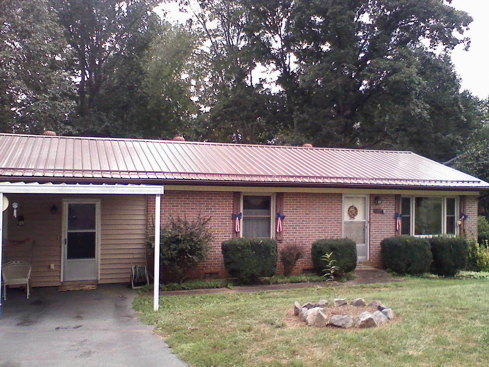 Bronze metal roof and carport on a brick ranch home — Roof Repair work by our crew in Portage Des Sioux